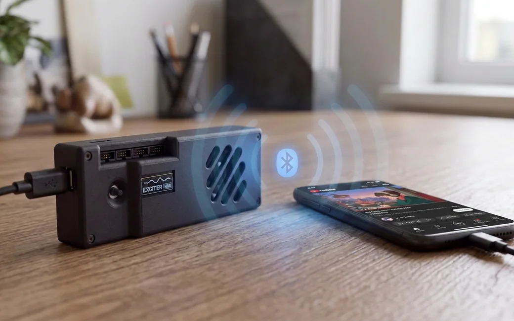 Exciter Mini on a desk streaming from a phone over Bluetooth, sound waves radiating